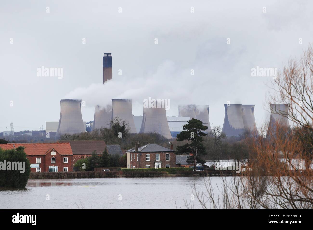 La centrale elettrica di Eggborough si trova dietro il villaggio inondato di East Cowick, nello Yorkshire, dopo una pioggia intensa e forti venti portati dalla tempesta Jorge hanno martoriato il Regno Unito durante la notte. Foto Stock