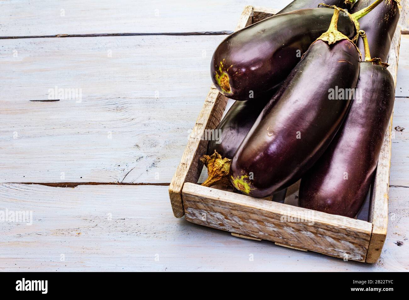 Uova fresche crude in scatola di legno. Raccogliere le verdure organiche come ingrediente fresco per cucinare cibi sani. Tavole di legno sfondo, copia spazio, c Foto Stock