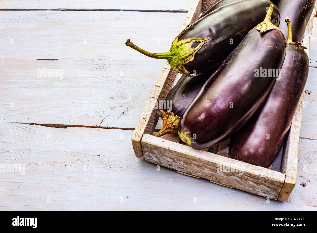 Uova fresche crude in scatola di legno. Raccogliere le verdure organiche come ingrediente fresco per cucinare cibi sani. Tavole di legno sfondo, copia spazio, c Foto Stock