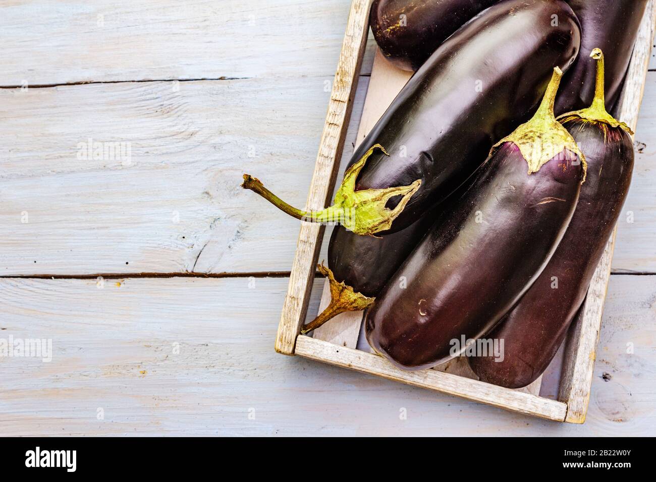 Uova fresche crude in scatola di legno. Raccogliere le verdure organiche come ingrediente fresco per cucinare cibi sani. Tavole di legno sfondo, copia spazio, t Foto Stock