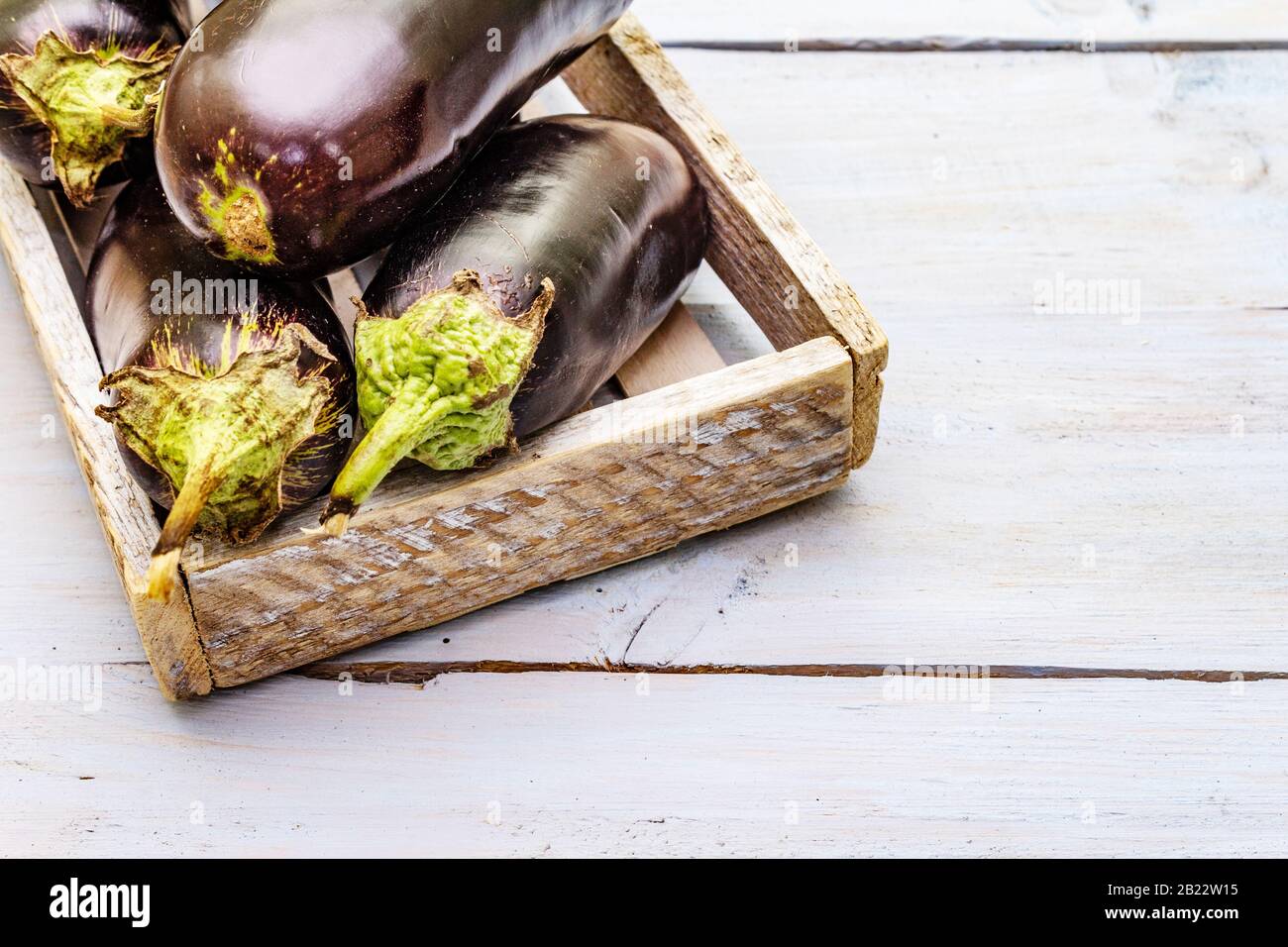 Uova fresche crude in scatola di legno. Raccogliere le verdure organiche come ingrediente fresco per cucinare cibi sani. Tavole di legno sfondo, copia spazio, c Foto Stock