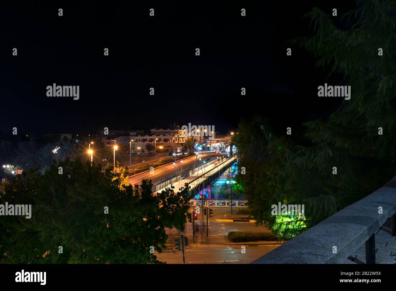 Il ponte del fiume Pinios e la rotonda in una foto notturna. Verniciatura leggera dalle luci dell'auto. Nella città di Larissa Foto Stock