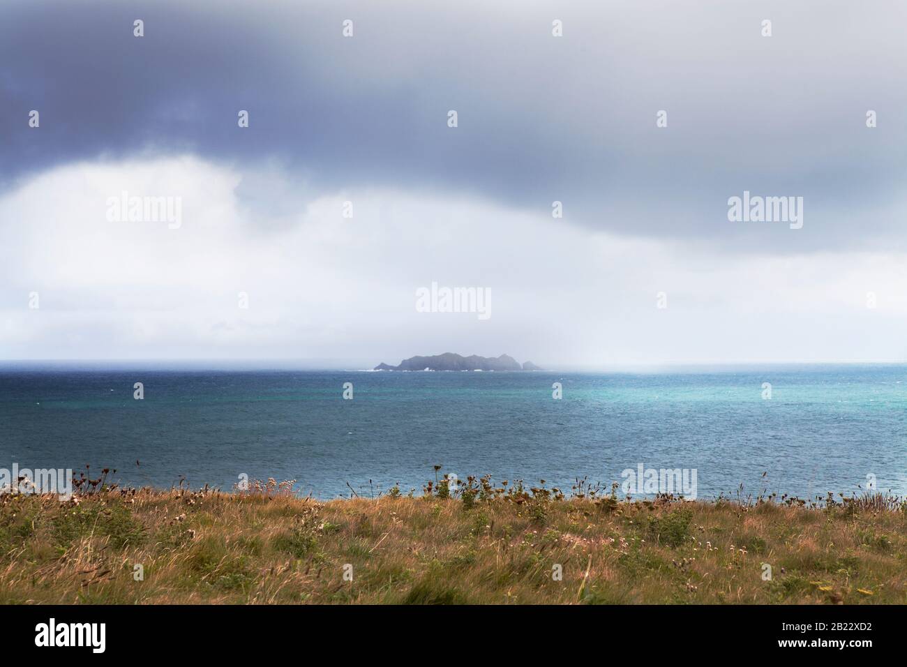 Una tempesta estiva rotola su Gulland Rock, vista da Cataclews Point sopra la spiaggia di surf di Harlyn Bay nel nord della Cornovaglia, Regno Unito. Foto Stock