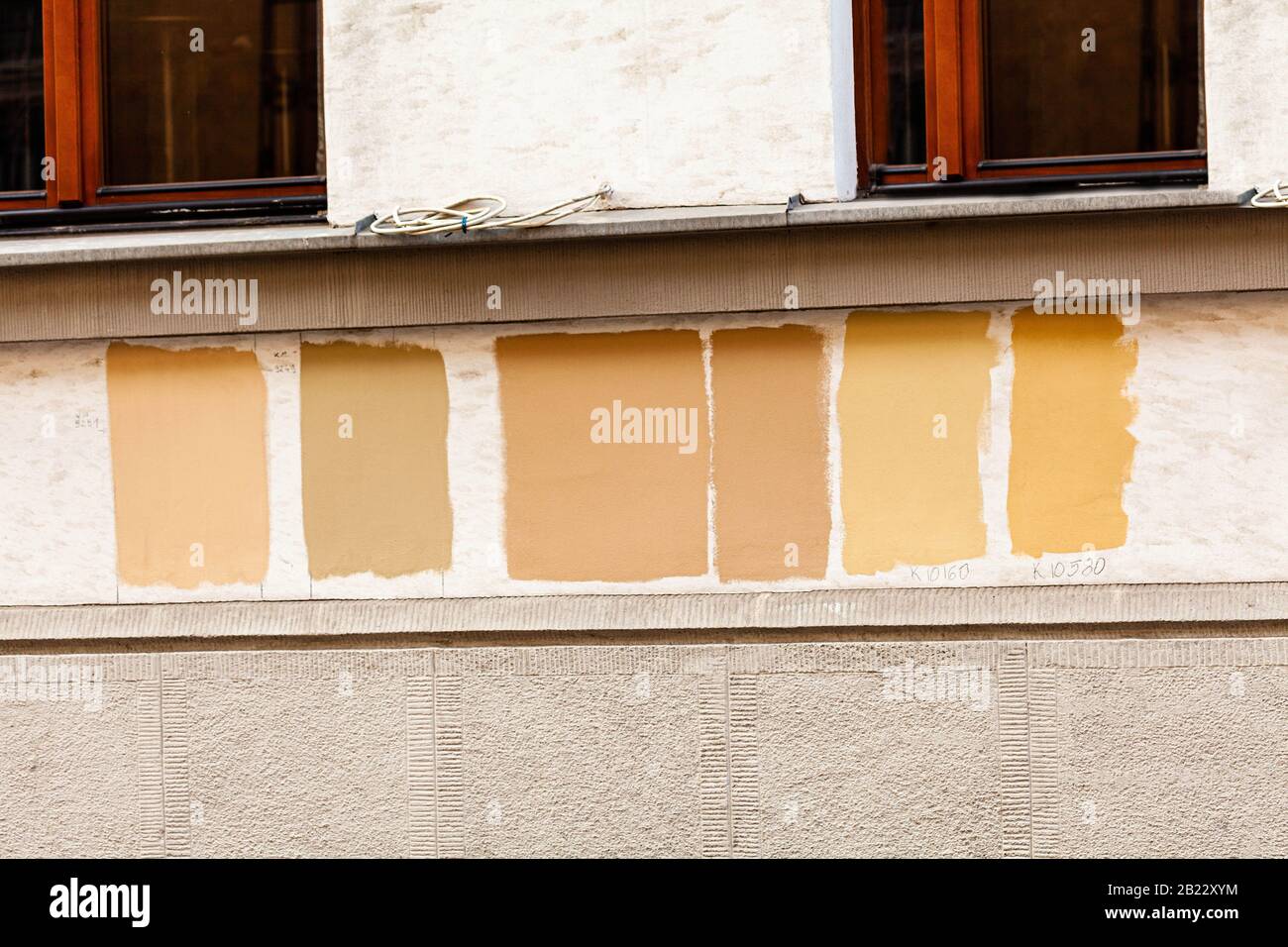 Verniciare i campioni di prova su una parete dell'edificio. Provando vari tipi di vernice, selezionando i colori nel processo di conservazione di una vecchia casa di inquilino Foto Stock