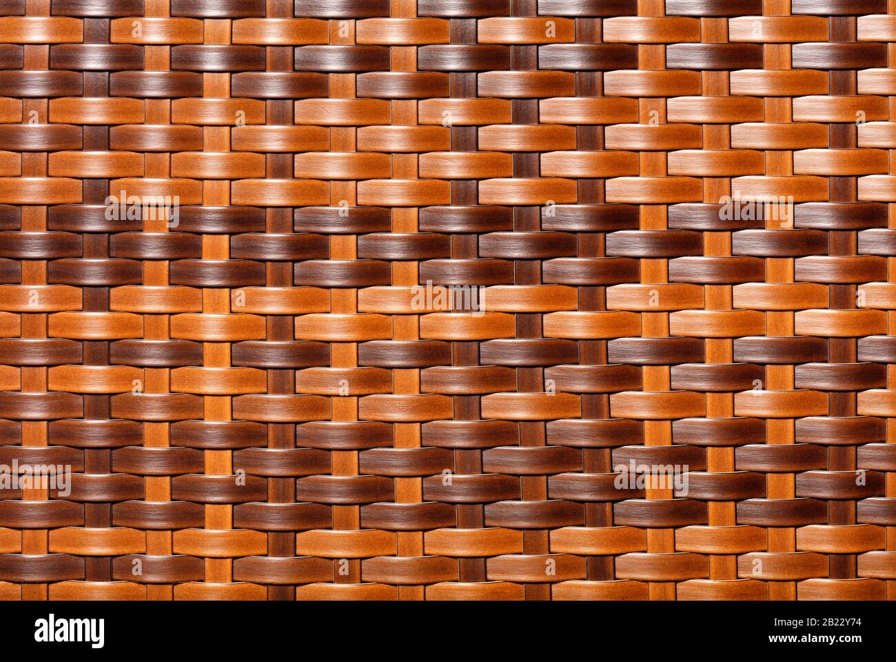 Marrone, marrone scuro, marrone chiaro, motivo di rattan artificiale. Primo piano della struttura del cestello. Arredamento sfondo e texture. Foto Stock