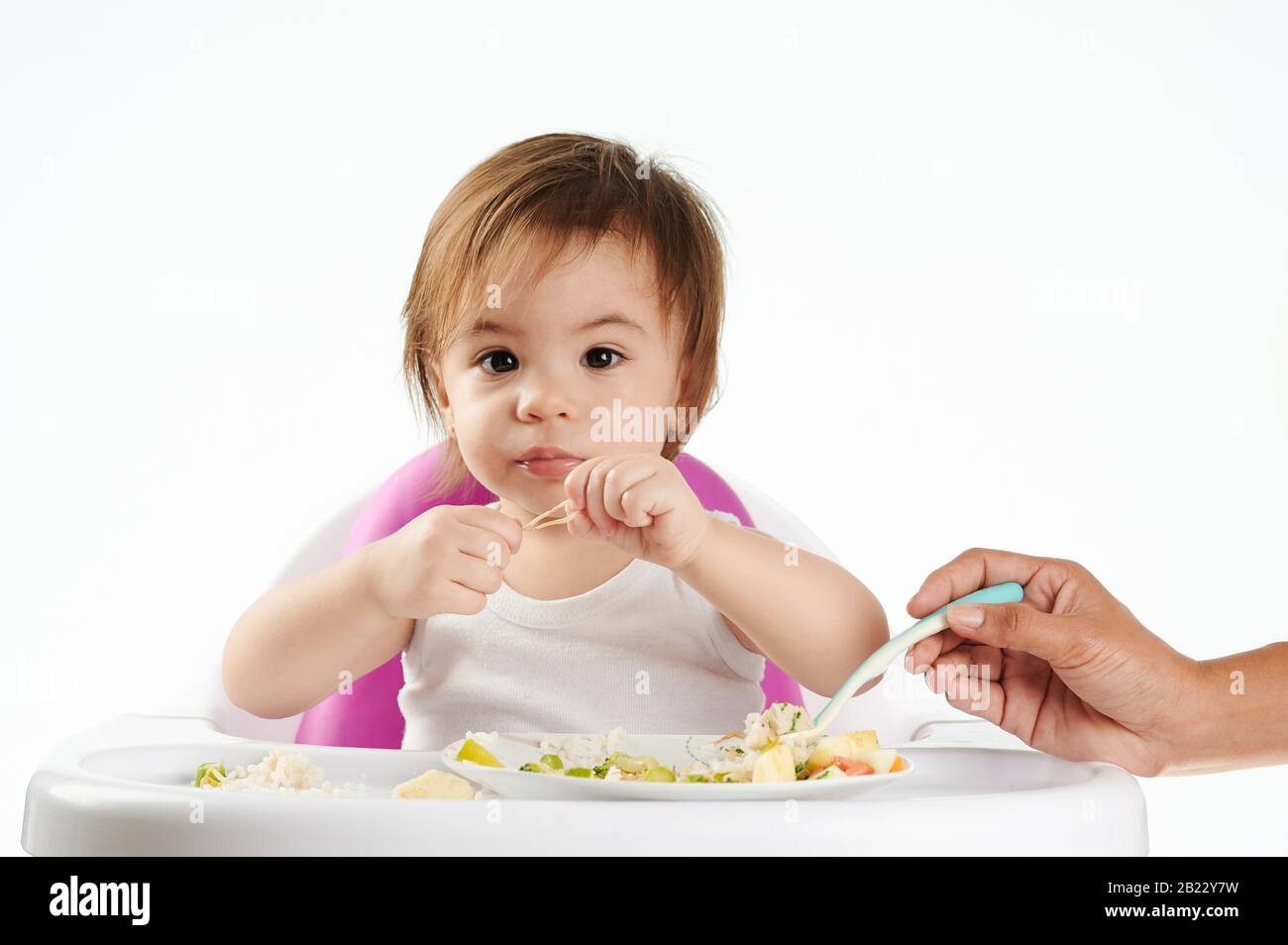 Afro americano che alimenta il bambino caucasico isolato su sfondo bianco Foto Stock