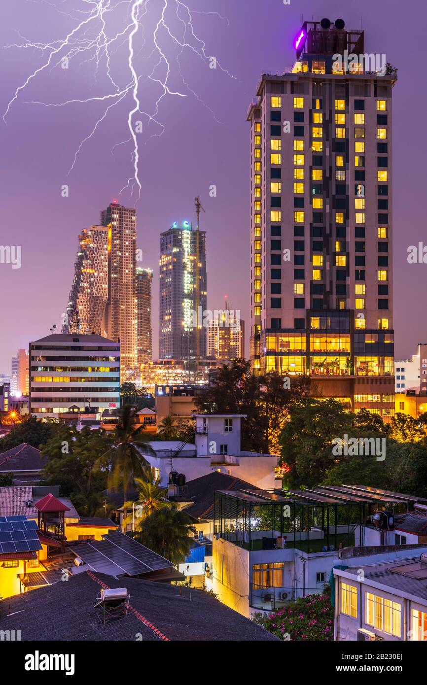 Dopo il caldo e umido calore della giornata, al tramonto il fulmine lampeggia sullo skyline di Colombo, la capitale dello Sri Lanka, si accende al tramonto. Colo Foto Stock