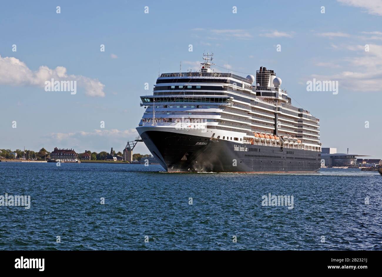 La nave da crociera M/S Eurodam, Holland America Line, lascia il porto di Copenhagen nel tardo pomeriggio, Danimarca. In background vecchi rigging sheers, Royal Opera House. Foto Stock