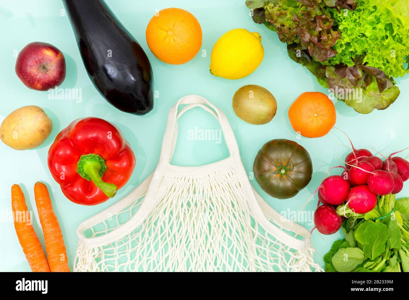 Verdure fresche e frutta intorno ad una maglia di shopping organica. Concetto di azione cosciente di natura-amichevole Foto Stock