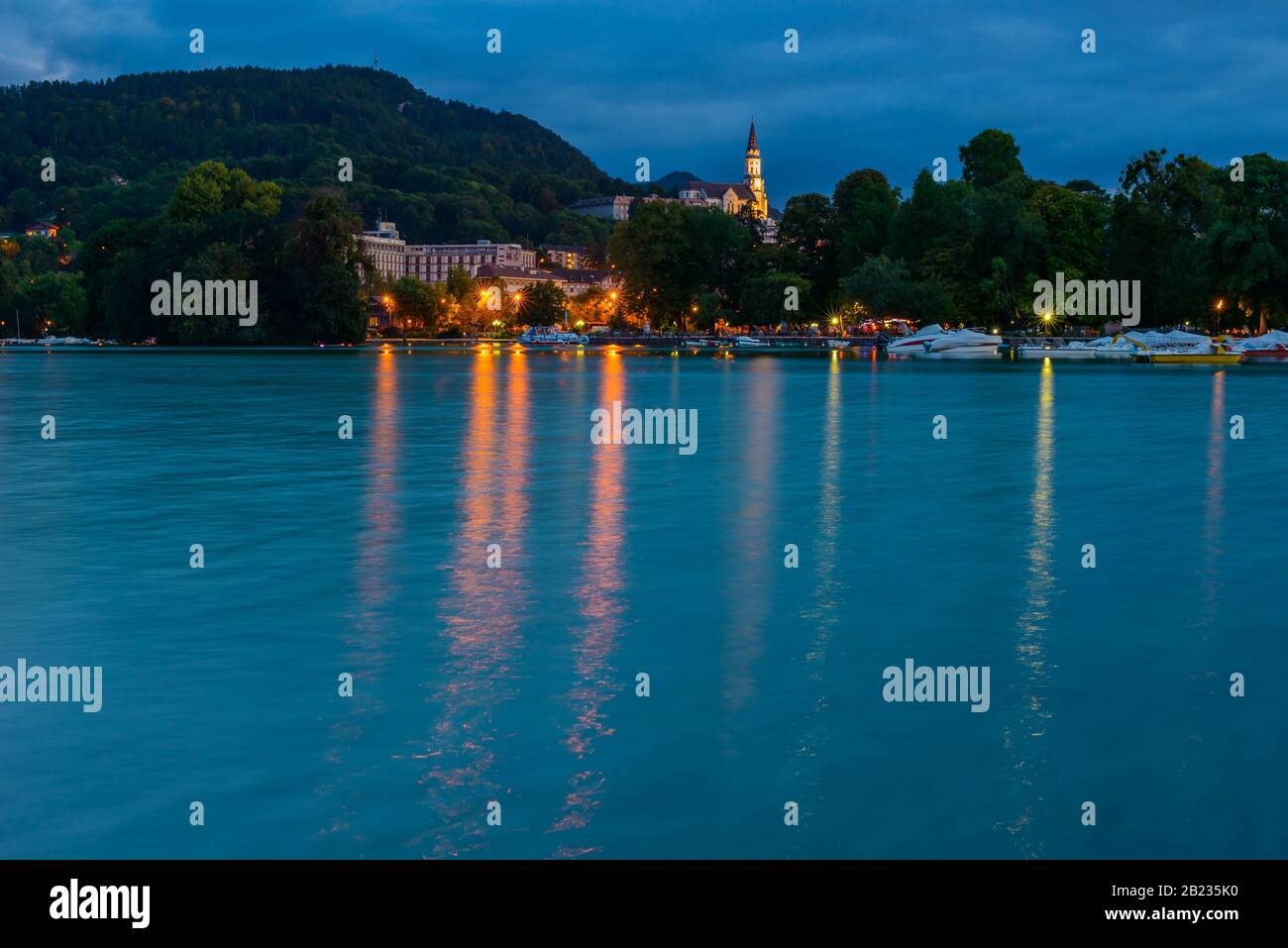 Lago di Annecy e l'elevata Basilica della Visitazione (Basilique de la Visitation), una basilica cattolica dei primi 20th secolo, al tramonto (Annecy, Francia). Foto Stock