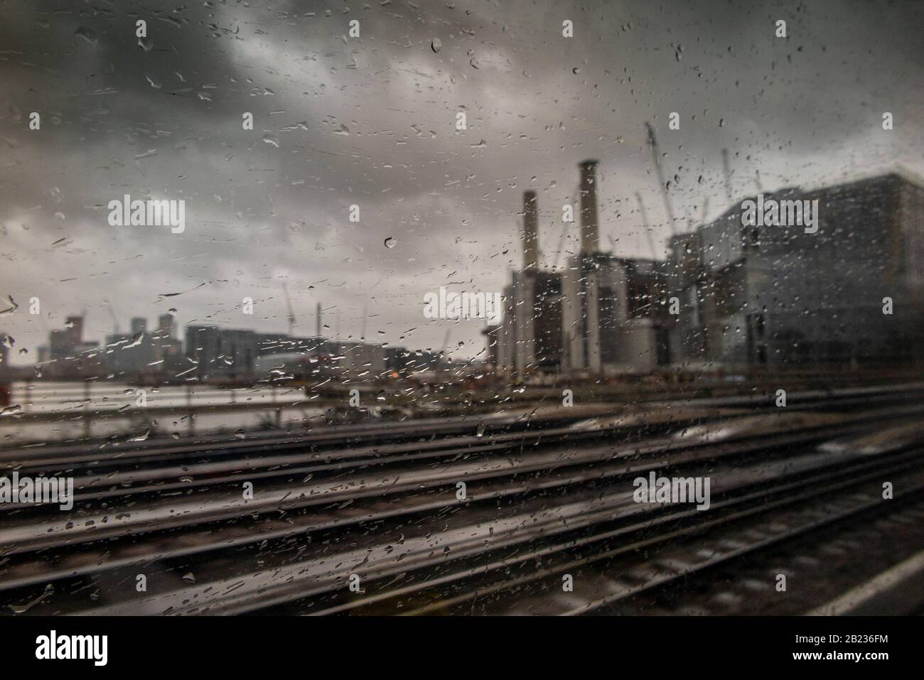 Pendolarismo per lavorare su un miserabile, piovoso, tempestoso giorno invernale con Battersea Power Station in lontananza Foto Stock