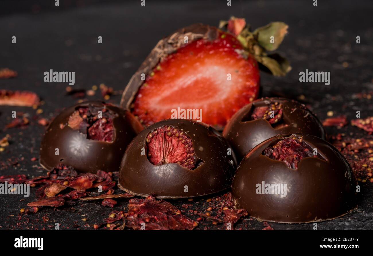 Cioccolatini belgi fatti in casa alla fragola secca su sfondo scuro Foto Stock