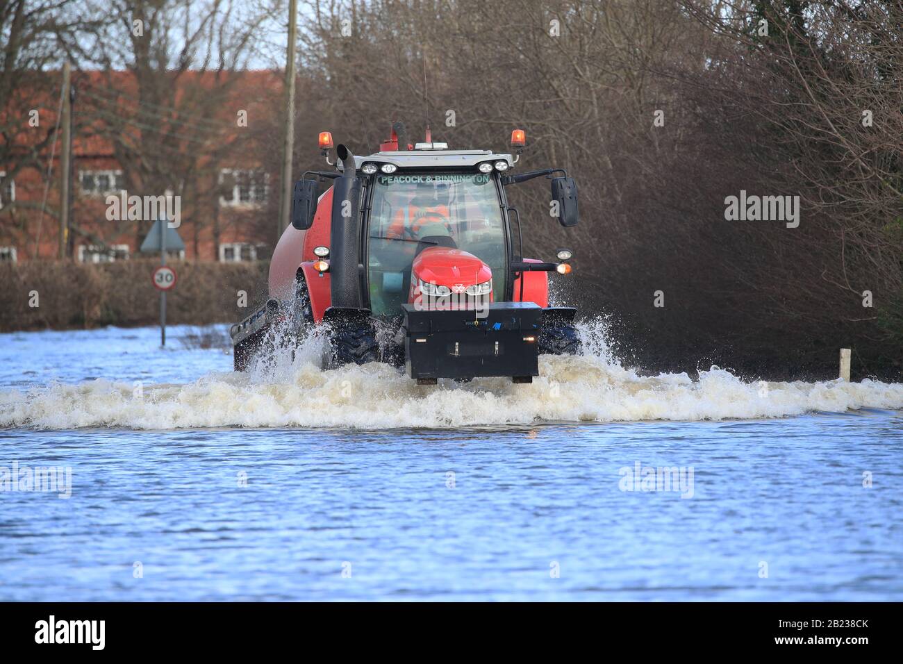 Un trattore attraversa l'acqua delle inondazioni a East Cowick, nello Yorkshire, dopo forti piogge e forti venti portati da Storm Jorge ha colpito il Regno Unito durante la notte. Foto Stock