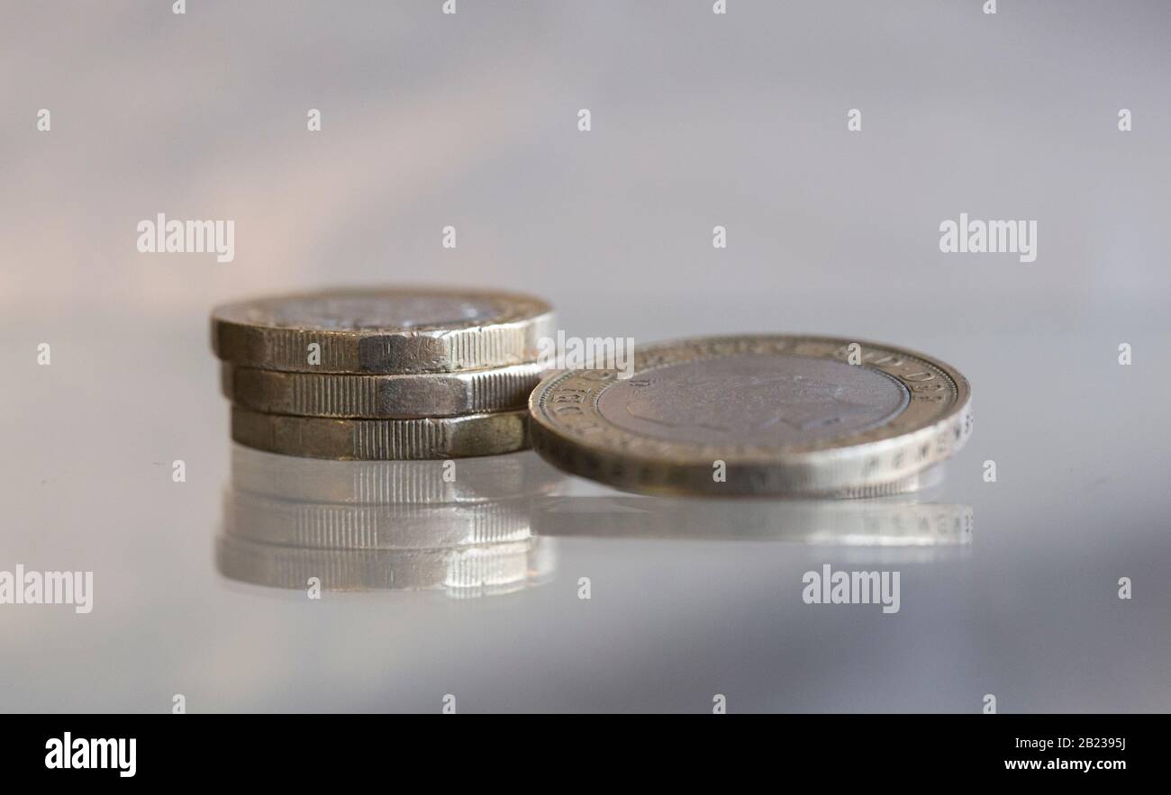 Monete da sterline inglesi e una macro da £2 su una superficie riflettente Foto Stock