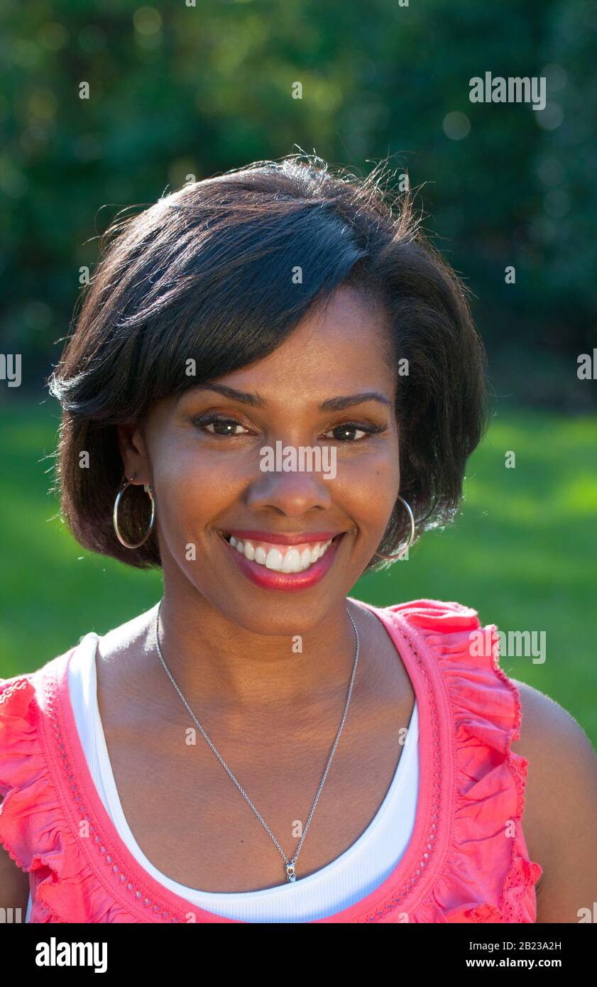 Donna nera di successo ritratto all'aperto sotto il sole con sorriso, MR: Sì Foto Stock