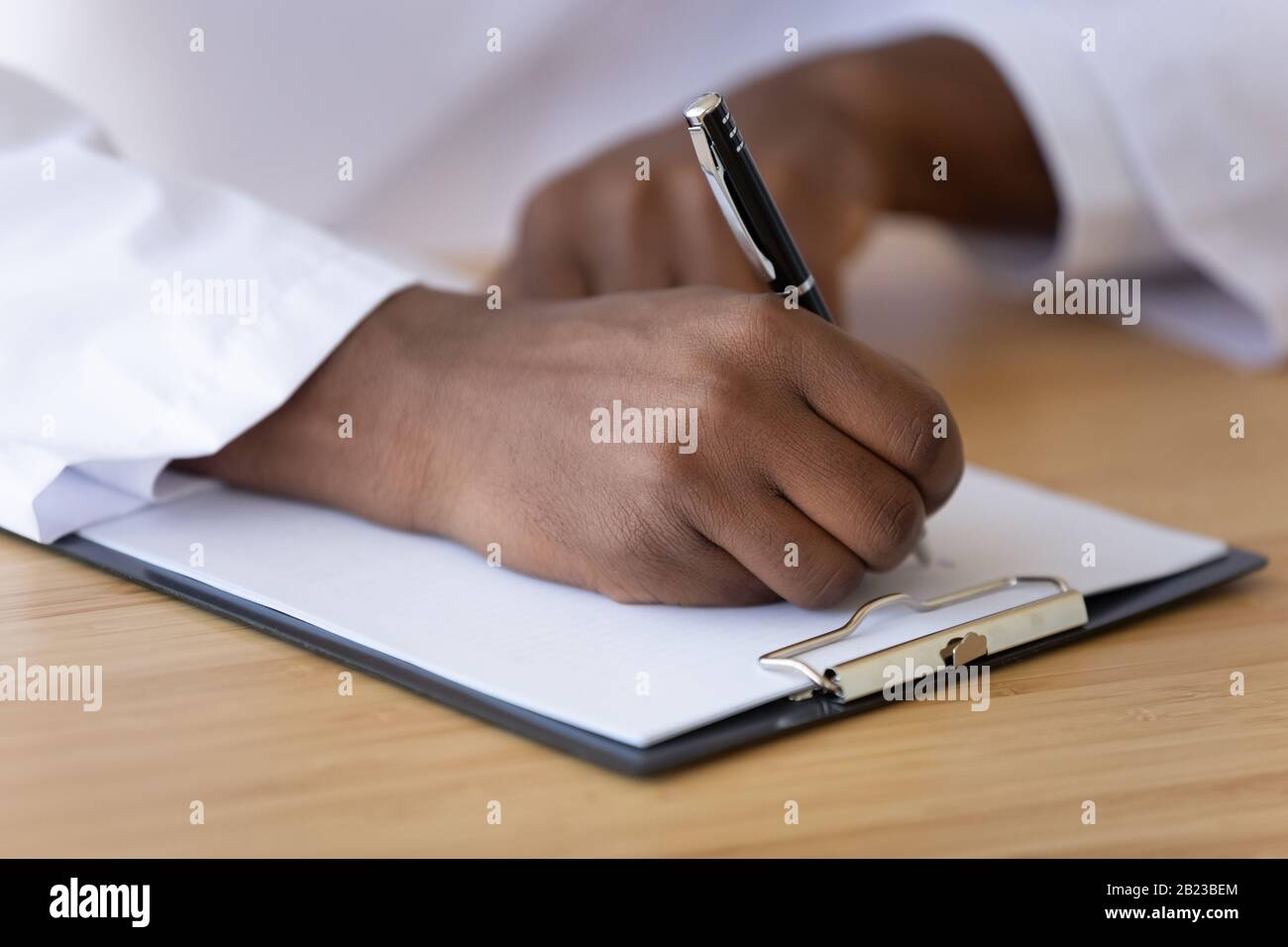 Medico afroamericano che compila il modulo di paziente primo piano Foto Stock