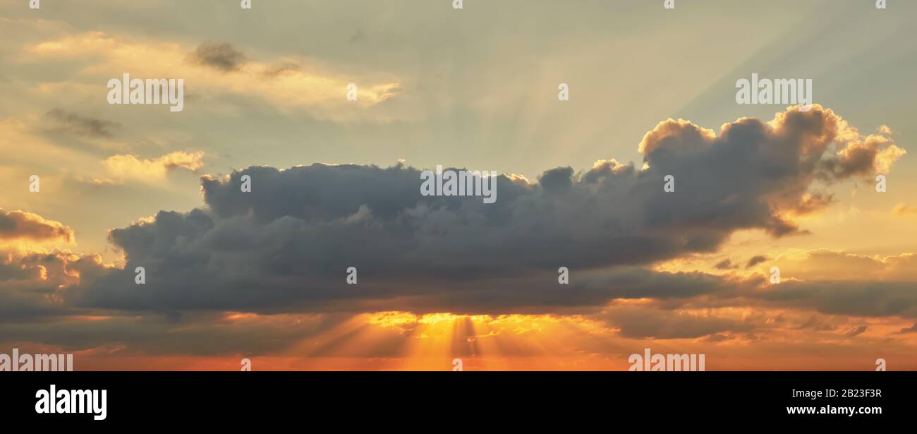 Bel cielo mediterraneo al tramonto in toni rossi e arancioni con raggi solari Foto Stock