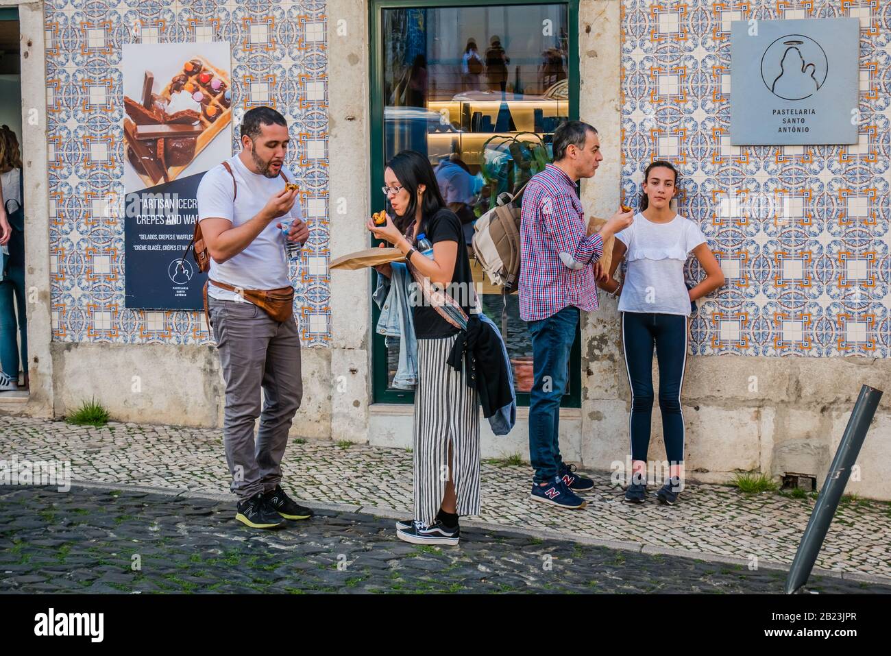 I turisti si trovano di fronte alla premiata pasticceria Pastelaria santo antonio nella zona di Alfama di Lisbona, Portogallo Foto Stock