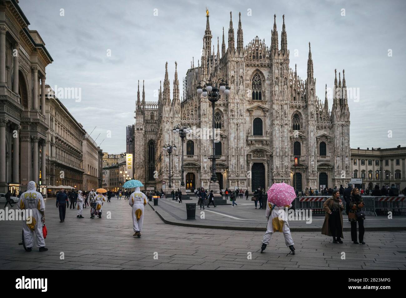 Clown vestiti in abiti chimici a Piazza Duomo in mezzo Coronavirus paure.Nonostante la modifica del decreto regionale che ordina la chiusura di bar, pub alle 18.00, i turisti richiedono rapidamente sceso per le preoccupazioni sulla sicurezza dei viaggi in Italia durante l'emergenza COVID-19. Anche il settore finanziario è stato colpito dall'emergenza, con un calo rilevante in Piazza Affari, operatori turistici e lavoratori dei ristoranti, attività culturali e del settore dell'intrattenimento, ha richiesto un rapido ritorno alla normalità o altre soluzioni per salvare il proprio business. Foto Stock
