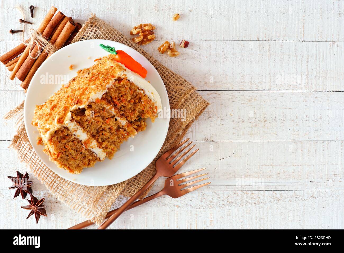 Fetta di torta di carote fatte in casa con crema di formaggio glassa. Sopra la vista su uno sfondo rustico di legno bianco. Foto Stock