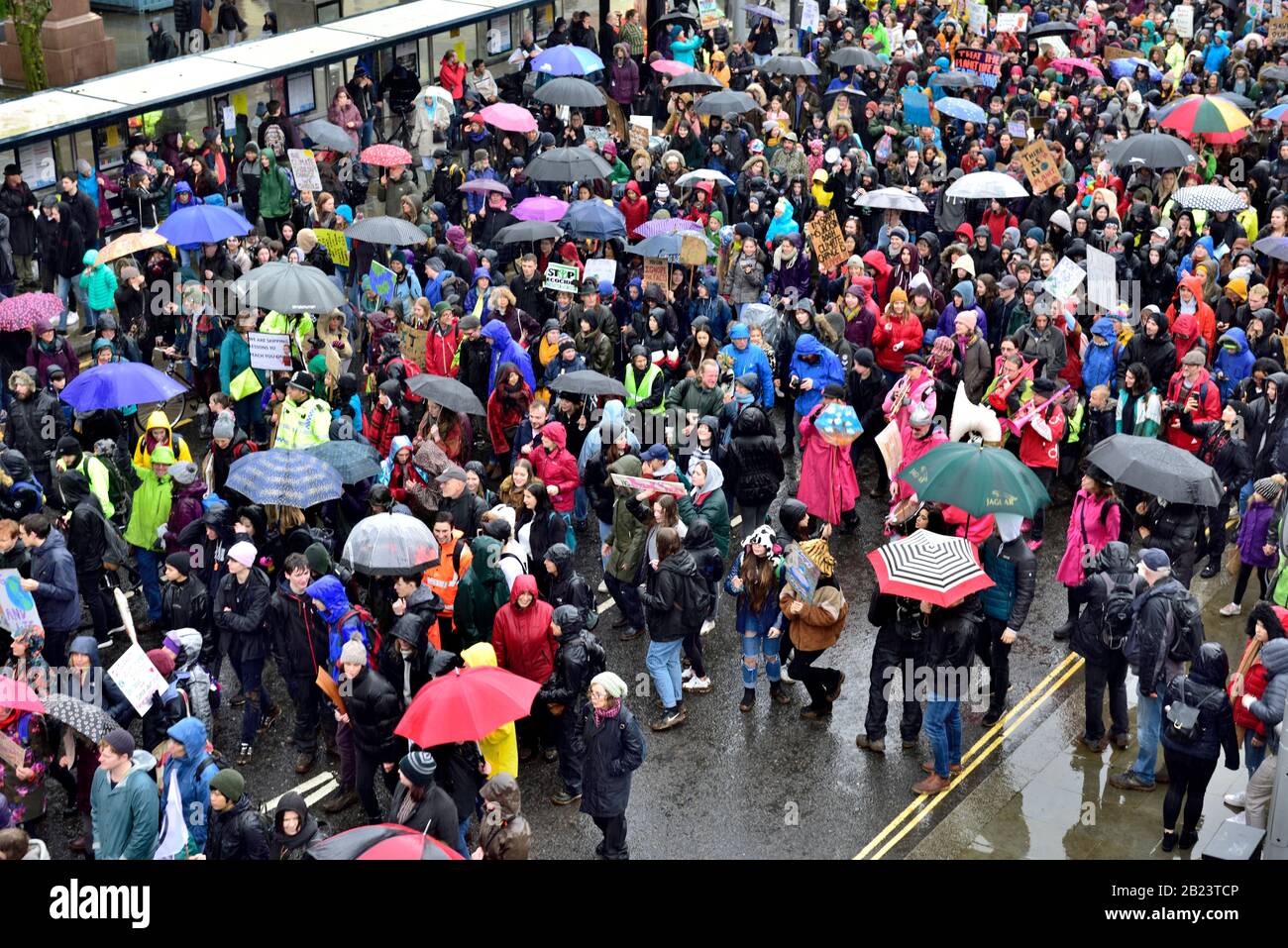 Folla di persone sotto la pioggia, molti con ombrelloni colorati per protesta climatica marzo Bristol Inghilterra 28 febbraio 2020 Foto Stock