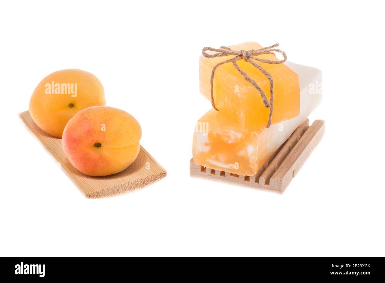 pila di saponette naturali e frutta di albicocca su bianco Foto Stock