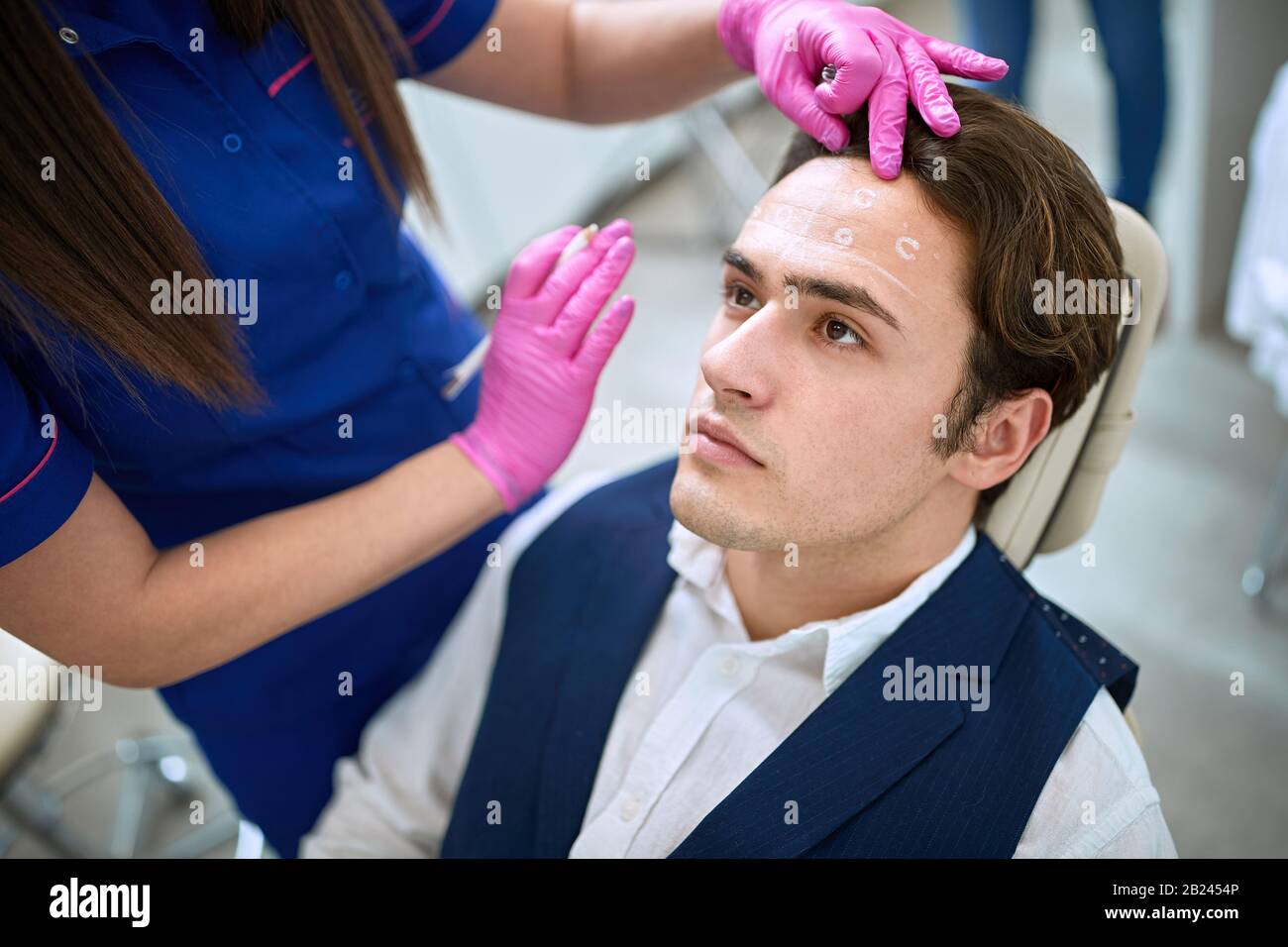 Uomo in clinica di bellezza riducendo le rughe sulla fronte Foto Stock