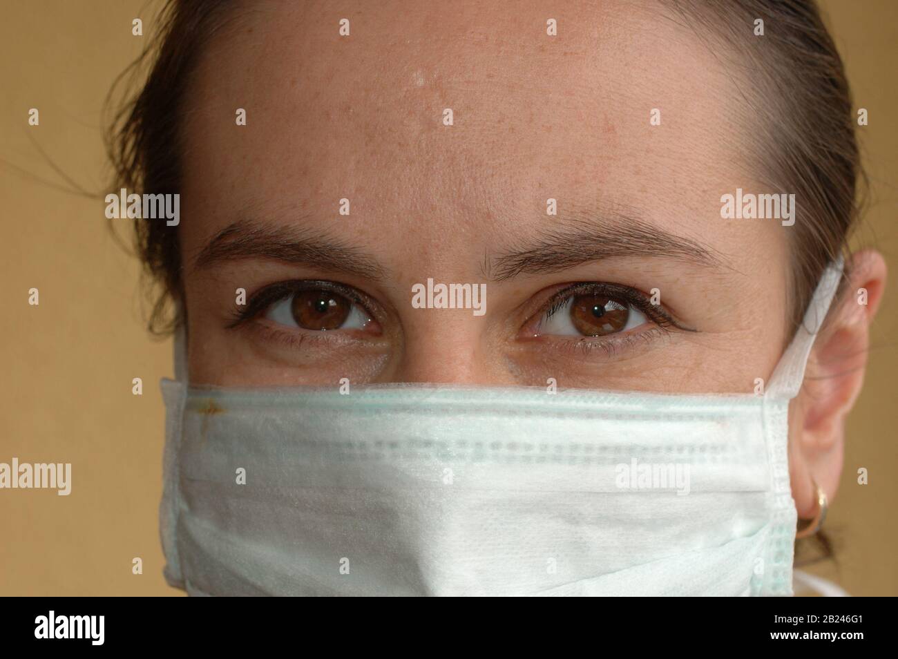 Operatore sanitario con maschera e sguardo concentrato Foto Stock
