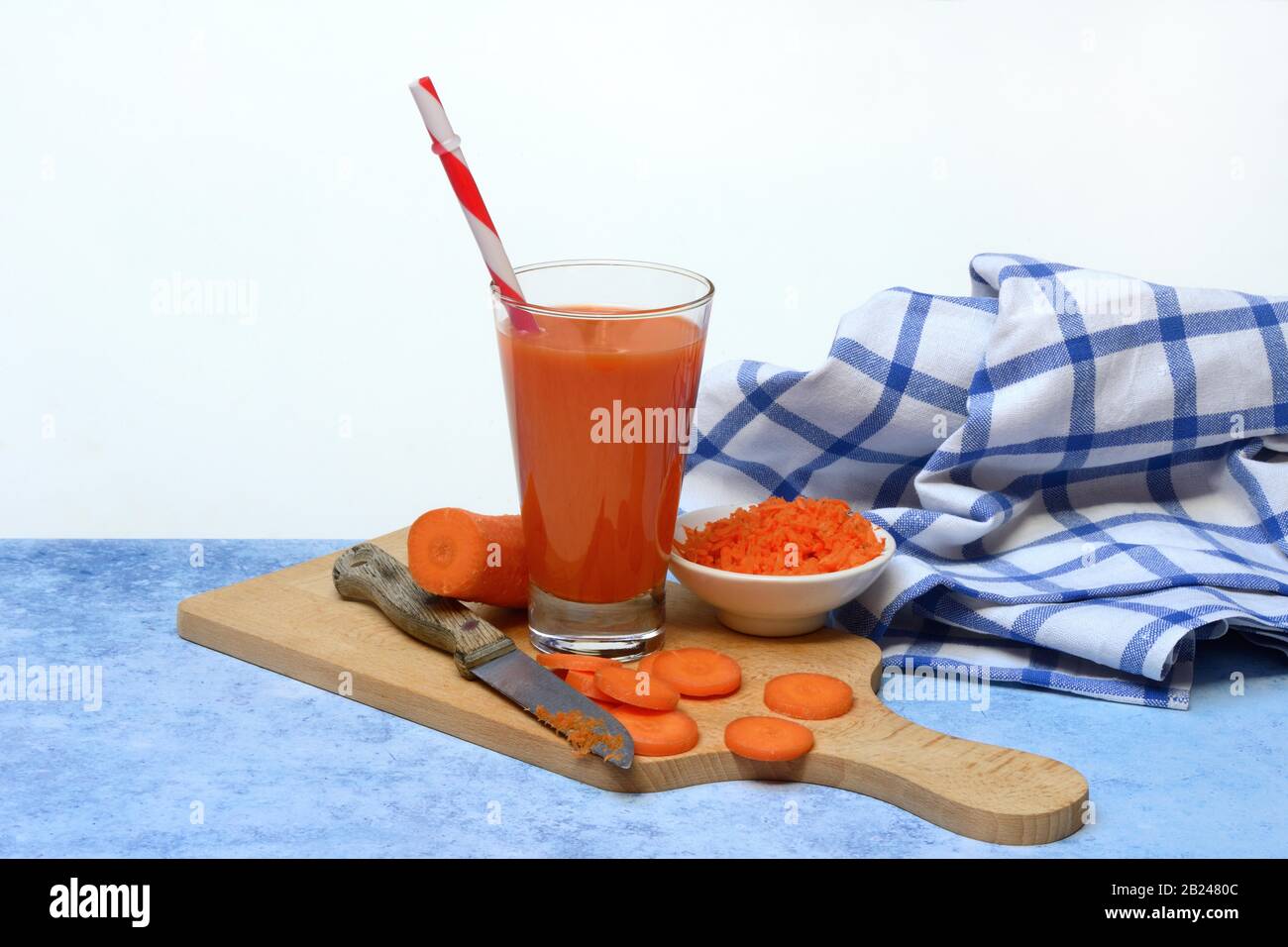 Succo di carota in fette di vetro e carota su tavole di legno, Germania Foto Stock