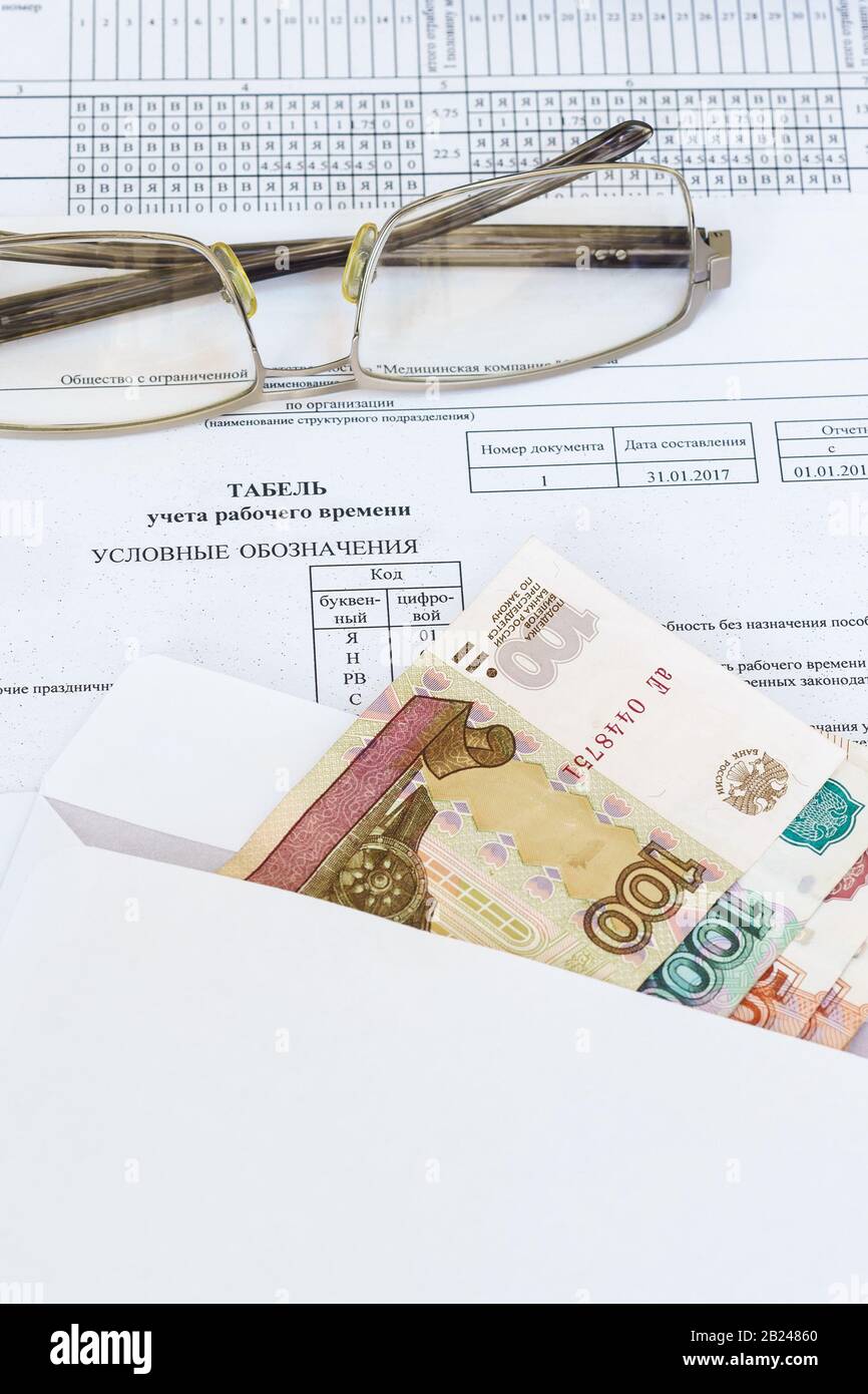 Occhiali e una busta con le fatture ruble che giacciono sul foglio di contabilità dell'orario di lavoro. Libro Paga. Russia Foto Stock