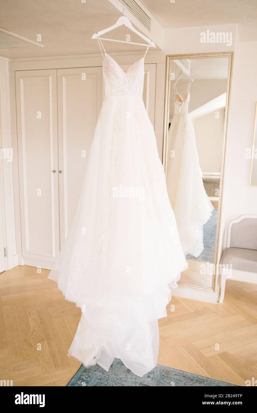 Un abito da sposa bianco appeso sull'appendiabiti. Acquisto di un abito da sposa. Foto Stock