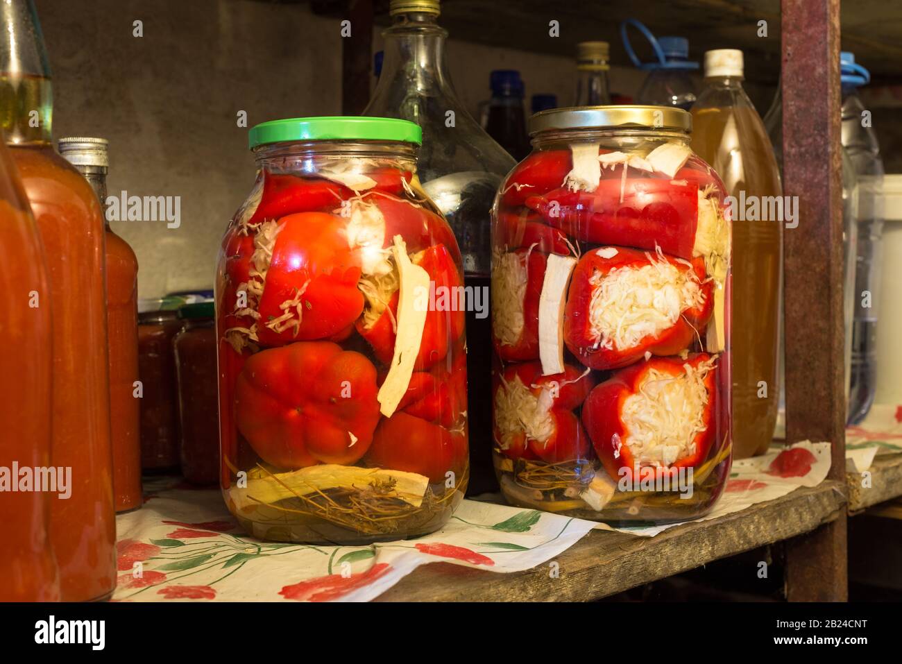 Bottiglie di vetro con peperoni sottaceto fatti in casa su un ripiano in una cantina in Ungheria Foto Stock