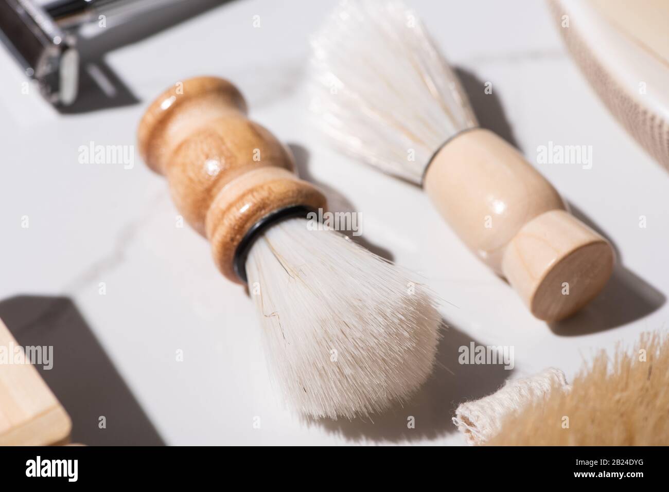 Messa a fuoco selettiva delle spazzole di rasatura su sfondo bianco, concetto di zero sprechi Foto Stock