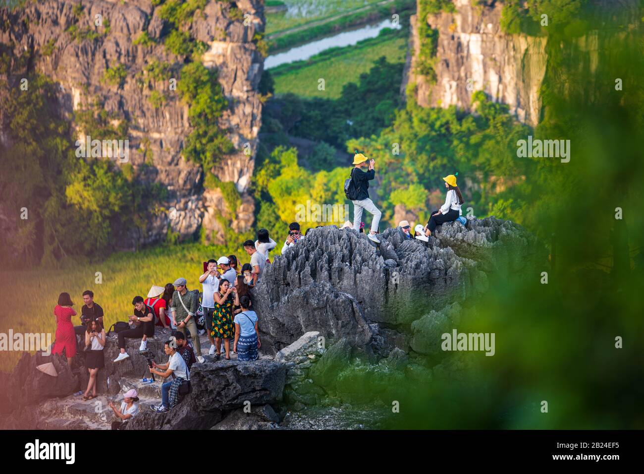 Durante il tramonto, i turisti possono scattare foto intorno a Pagodas alle Grotte di Mua - Vietnam Foto Stock