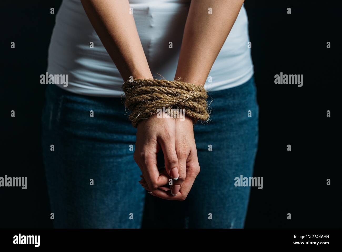 Vista ritagliata delle mani Delle Vittime legate con corda isolata su nero Foto Stock