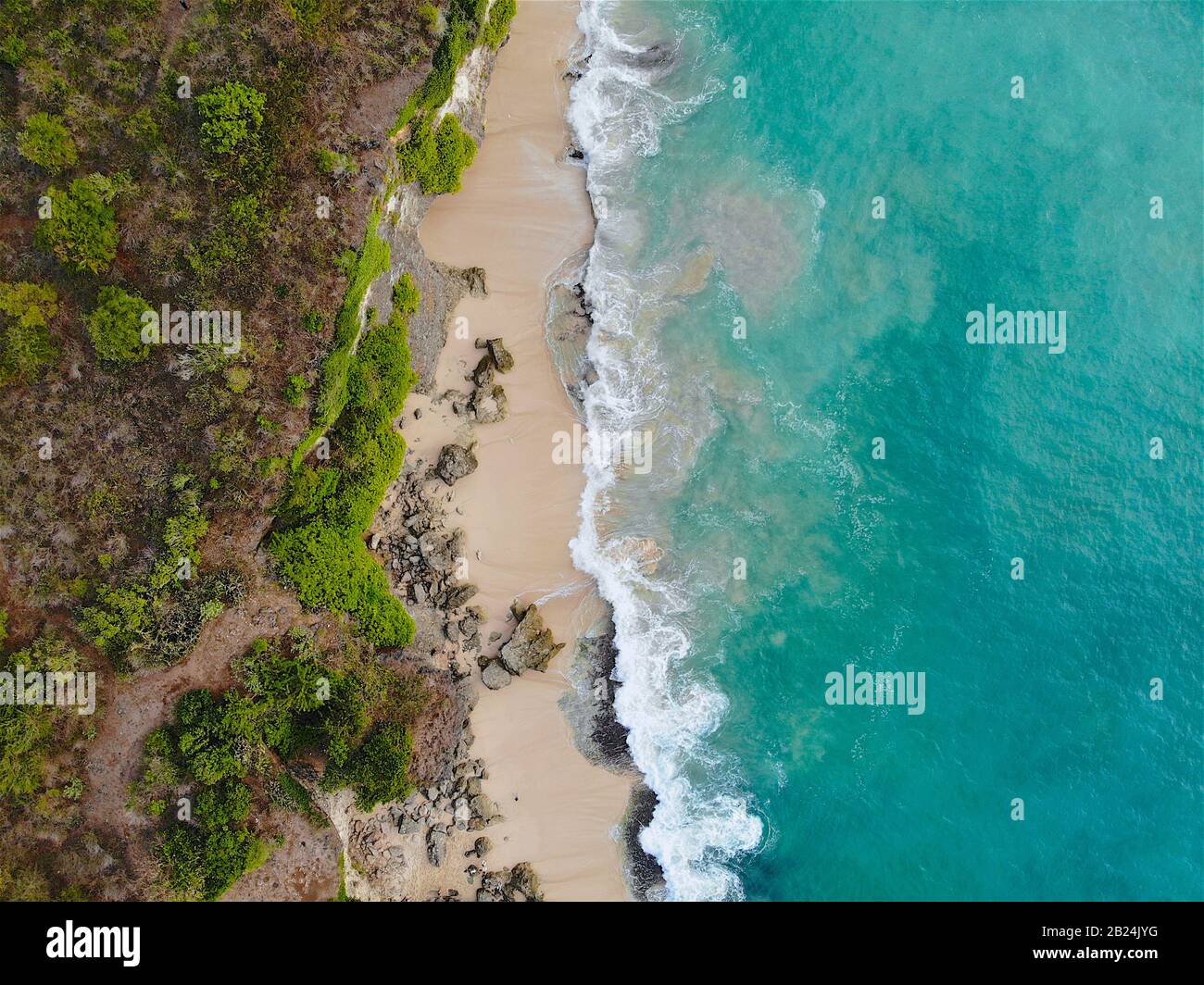 Veduta aerea di una bellissima spiaggia di sabbia con rocce e onde che rotolano sulla riva, Bali, Indonesia Foto Stock