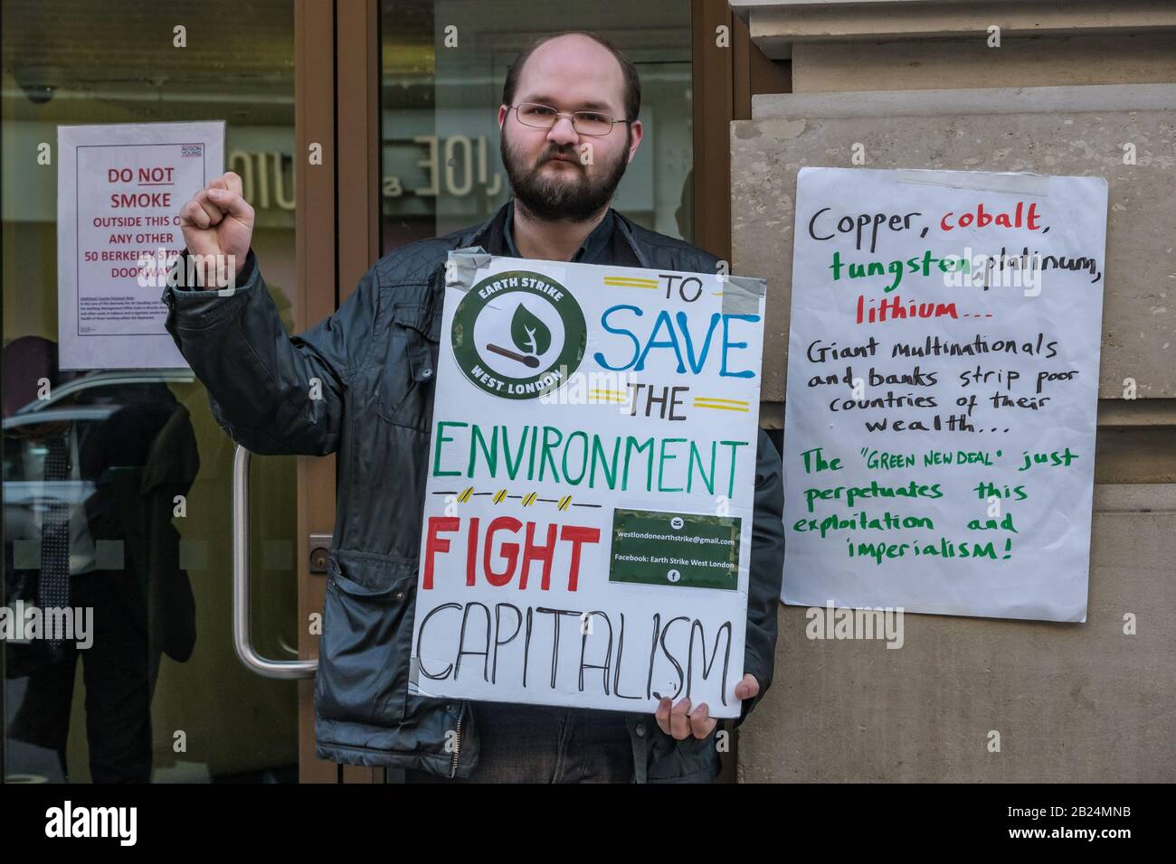 Londra, Regno Unito. 29th febbraio 2020. "Salvare l'ambiente combattere Il Capitalismo". Earth Strike e altri attivisti del clima protestano contro gli uffici di Mayfair, in parte la multinazionale mineraria britannica Glencore. Uno dei maggiori produttori mondiali di carbone, traggono profitto dalla distruzione ecologica per estrarre minerali come cobalto, rame e litio vitali in smartphone, computer e automobili elettriche. Le famiglie congolesi li stanno facendo causa di bambini uccisi o mutilati nelle loro miniere, e i manifestanti contro le loro miniere in diversi paesi sono stati violentemente attaccati dalla polizia o uccisi. Peter Marsh Foto Stock