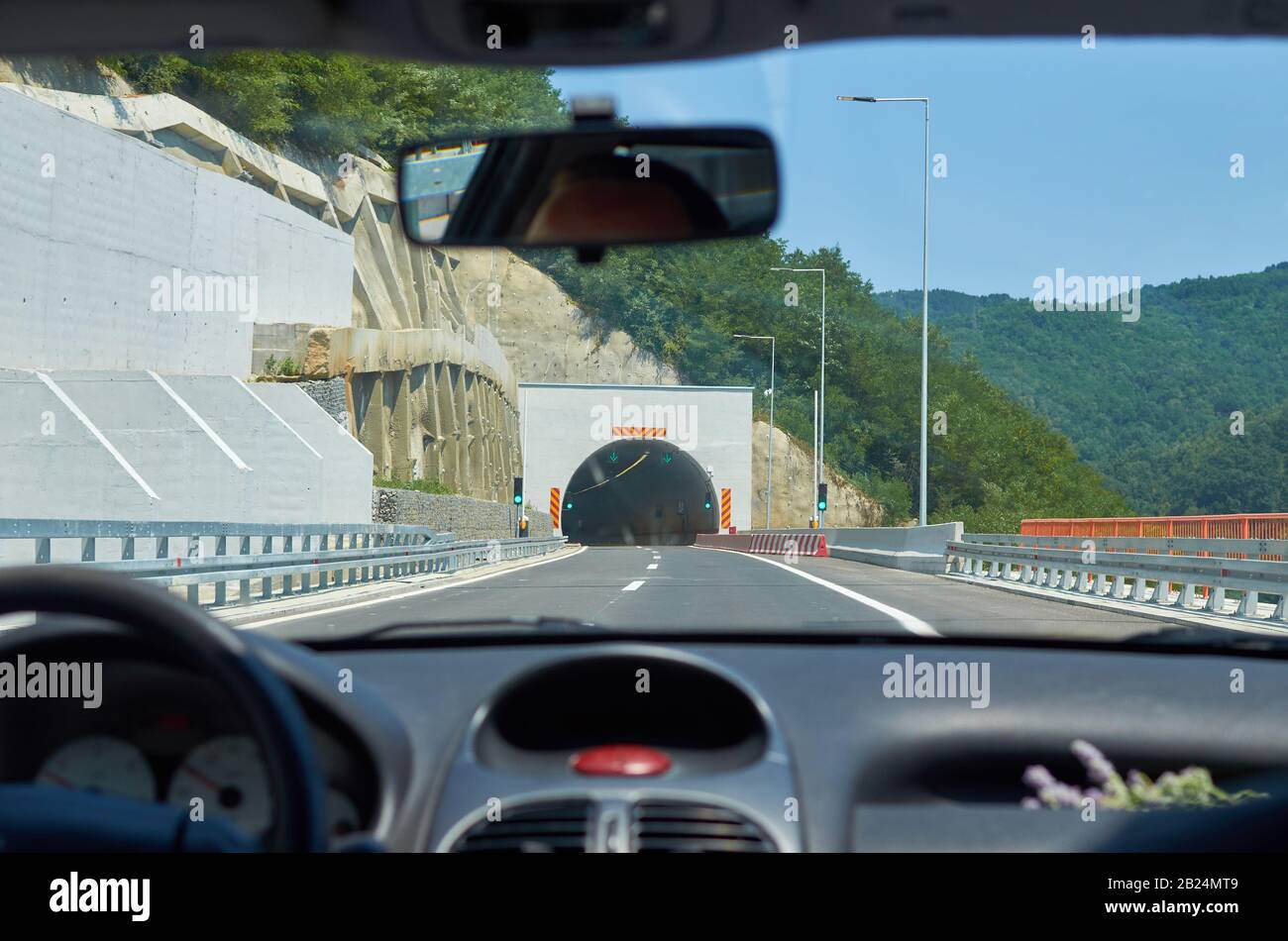 Auto che si avvicina a un tunnel durante un viaggio in autostrada Foto Stock