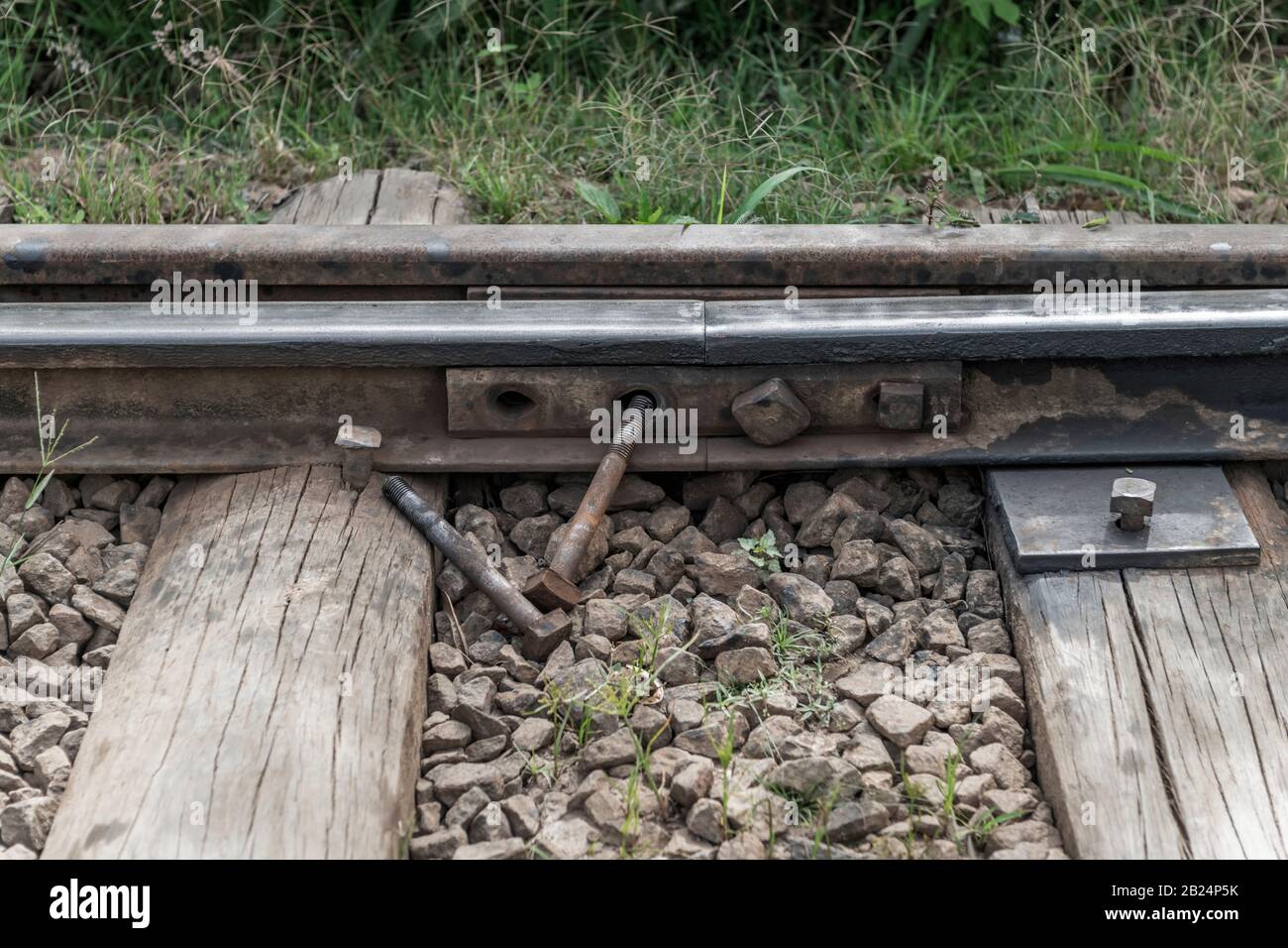 Due bulloni sono chiaramente visibili disalloggiati da un giunto tra due rotaie su una ferrovia dello Sri Lanka. Foto Stock