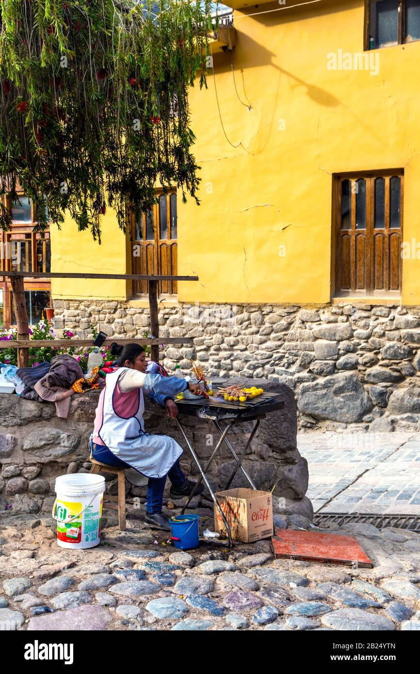 Donna che gestisce un cibo peruviano cibo di strada stalla a Ollantaytambo, Perù Foto Stock