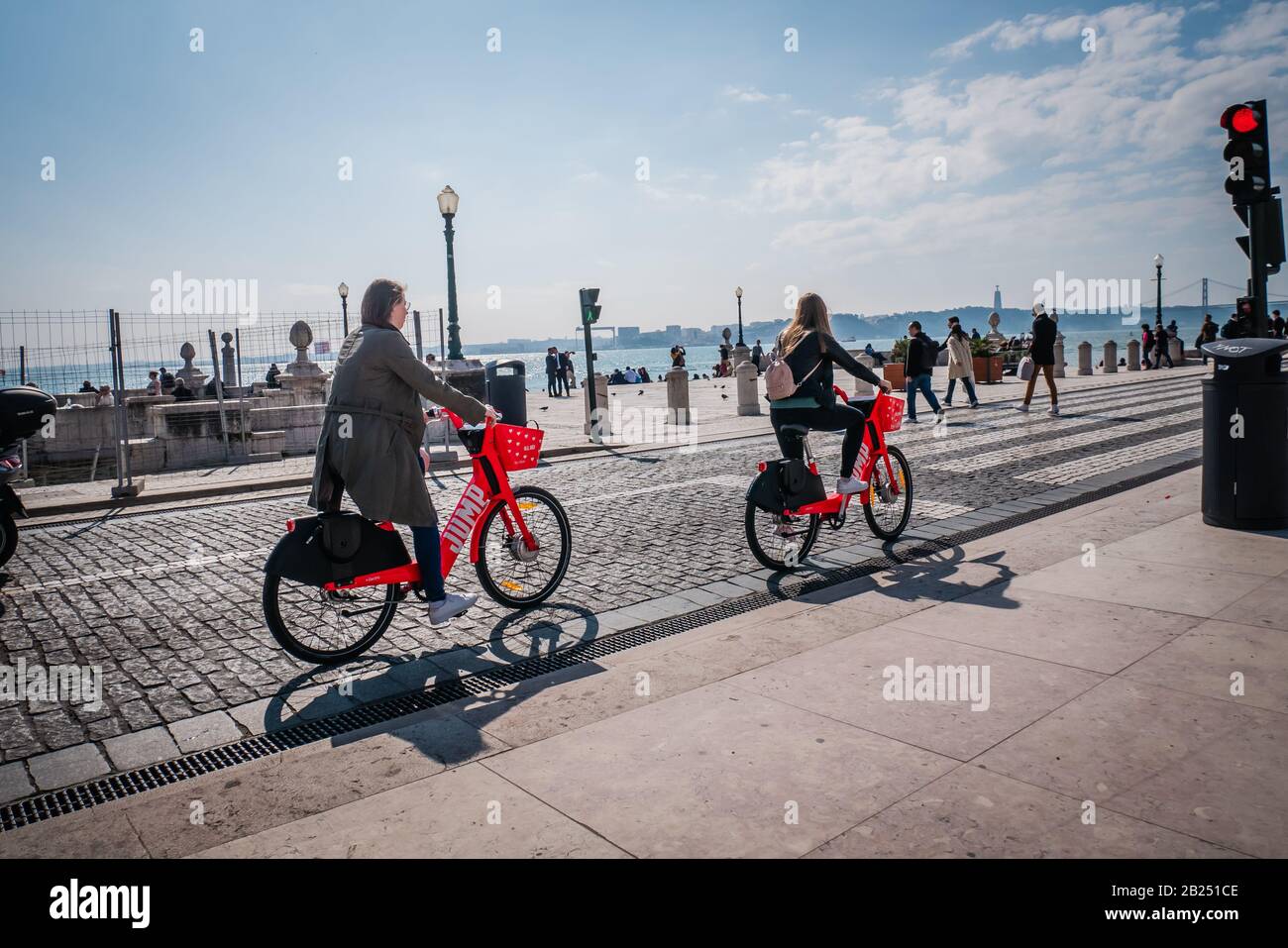 Due turisti donne in bicicletta lungo il fiume Tago a Lisbona Portogallo Foto Stock