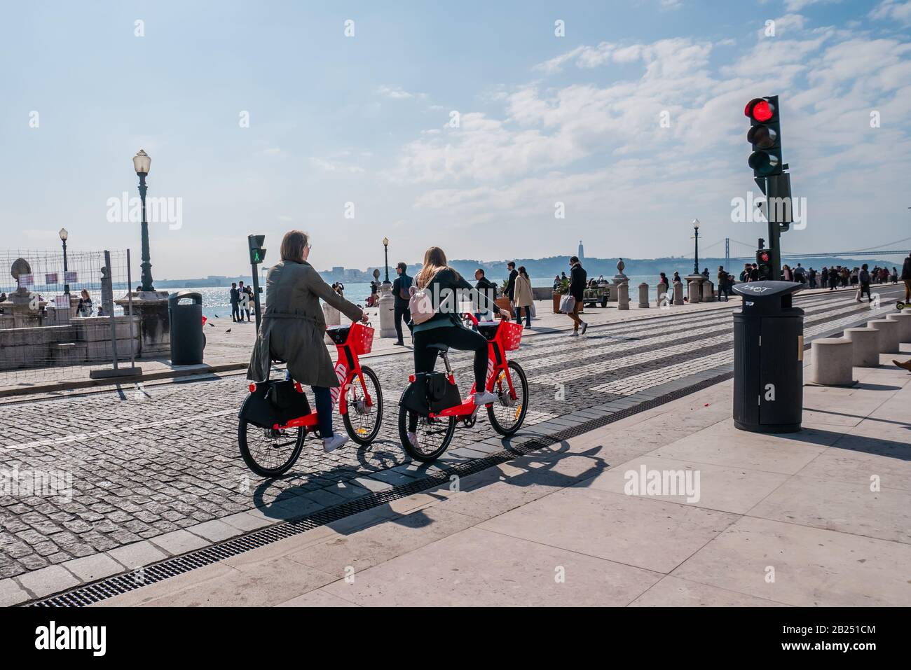 Due turisti donne in bicicletta lungo il fiume Tago a Lisbona Portogallo Foto Stock