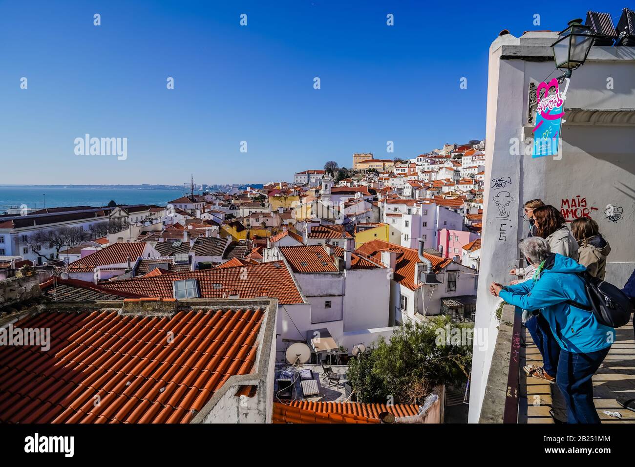 Un gruppo di turisti in un punto panoramico di Lisbona che si affaccia sulla città durante una giornata di sole Foto Stock