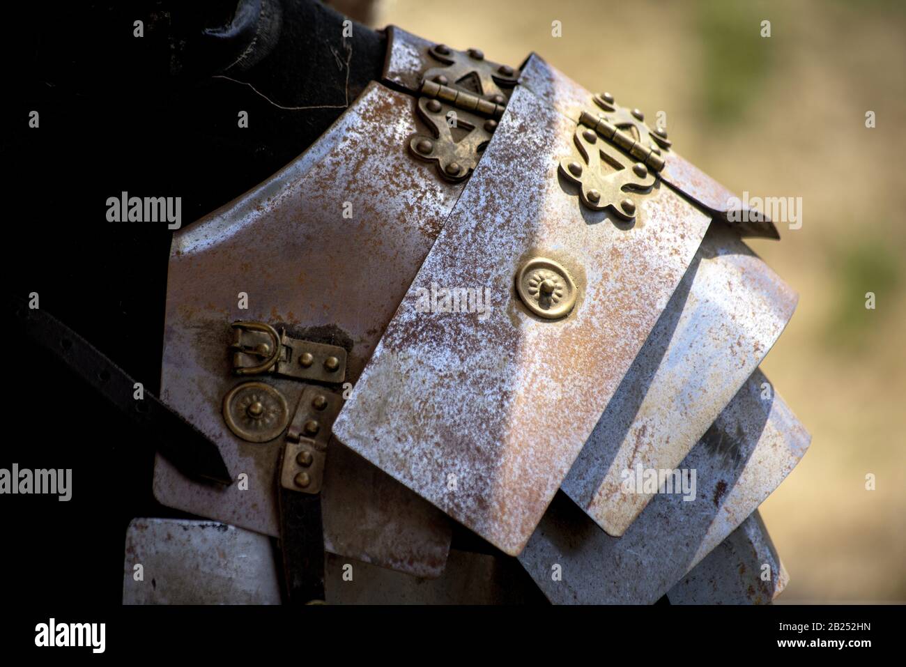 Vista ravvicinata dell'armatura metallica arrugginita e degli elaborati rivetti in oro Foto Stock