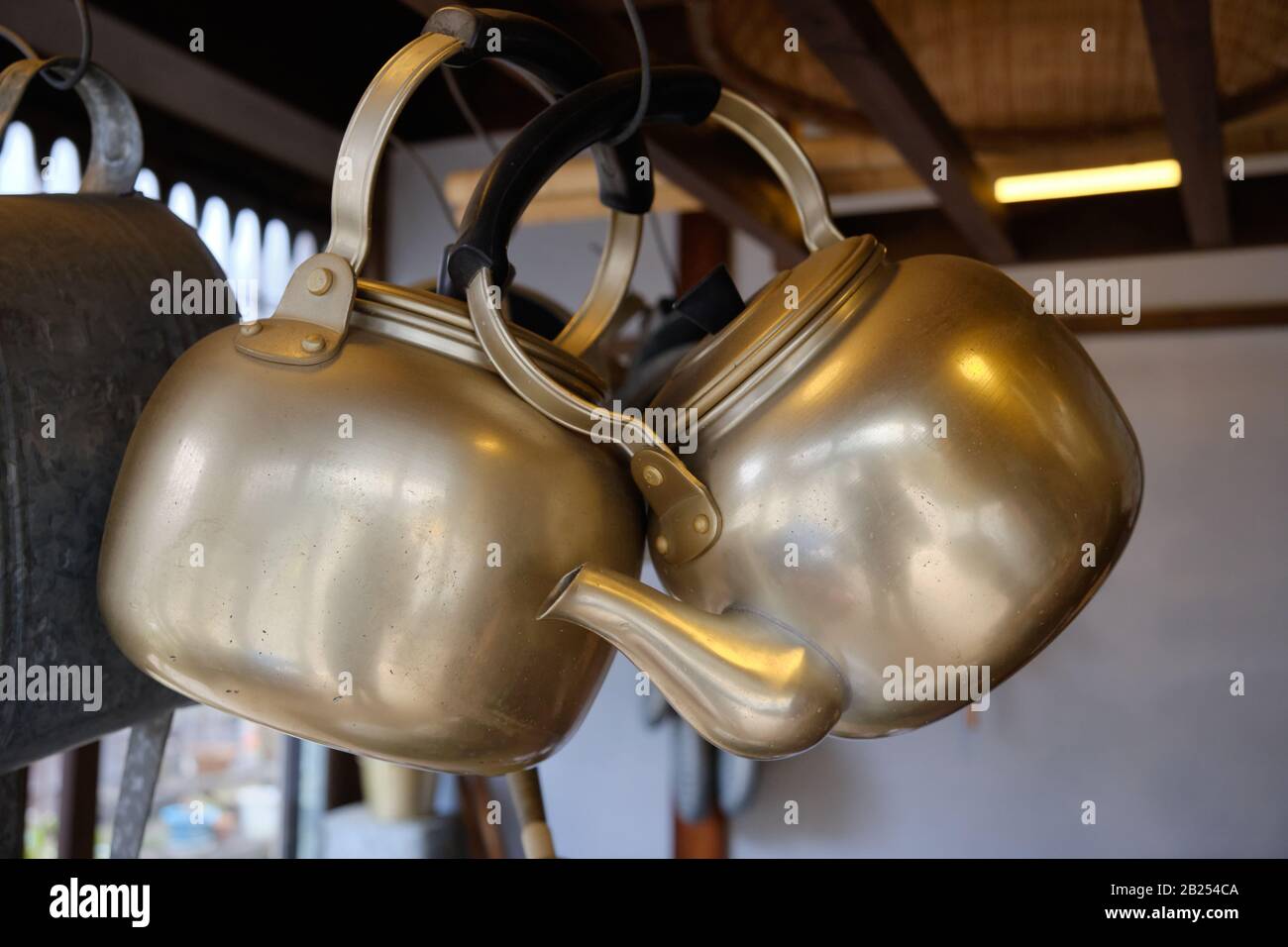 Teapots in ottone appesi in un negozio di ferramenta vecchio stile a Tokyo, Giappone. Foto Stock