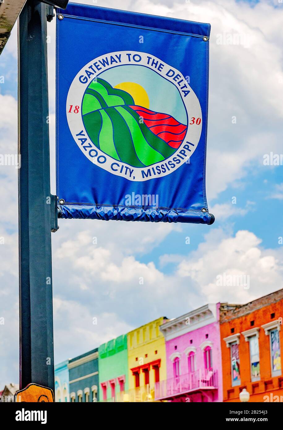 Un banner stradale è pubblicato su un lampione sullo sfondo di colorati negozi del centro, il 27 luglio 2019, a Yazoo City, Mississippi. Foto Stock