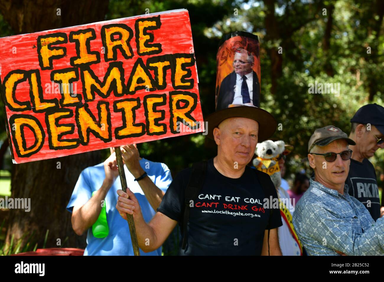 Un protestante in occasione di un incontro sul cambiamento climatico a Sydney con un cappello Scott Morrison e un cartello Foto Stock