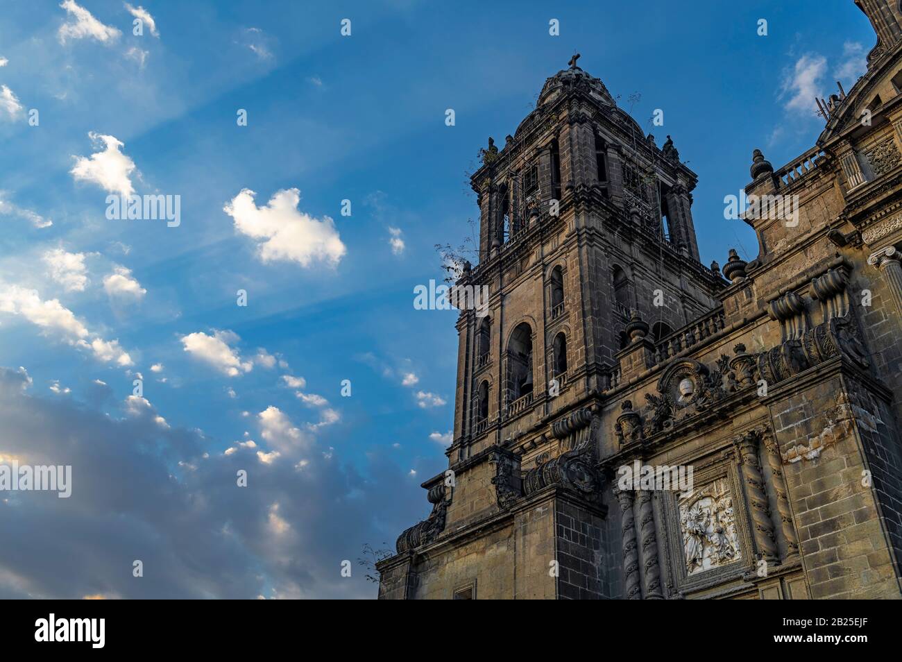 Facciata e torre della Cattedrale Metropolitana di Città del Messico con un raggio di sole che illumina la facciata, Messico. Foto Stock