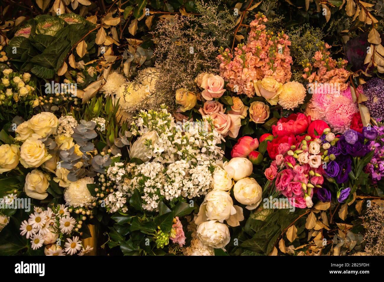 Mostra floreale di rose rosa bianche, margherite, fiori e verde fogliame ideale come sfondo sfondo Foto Stock