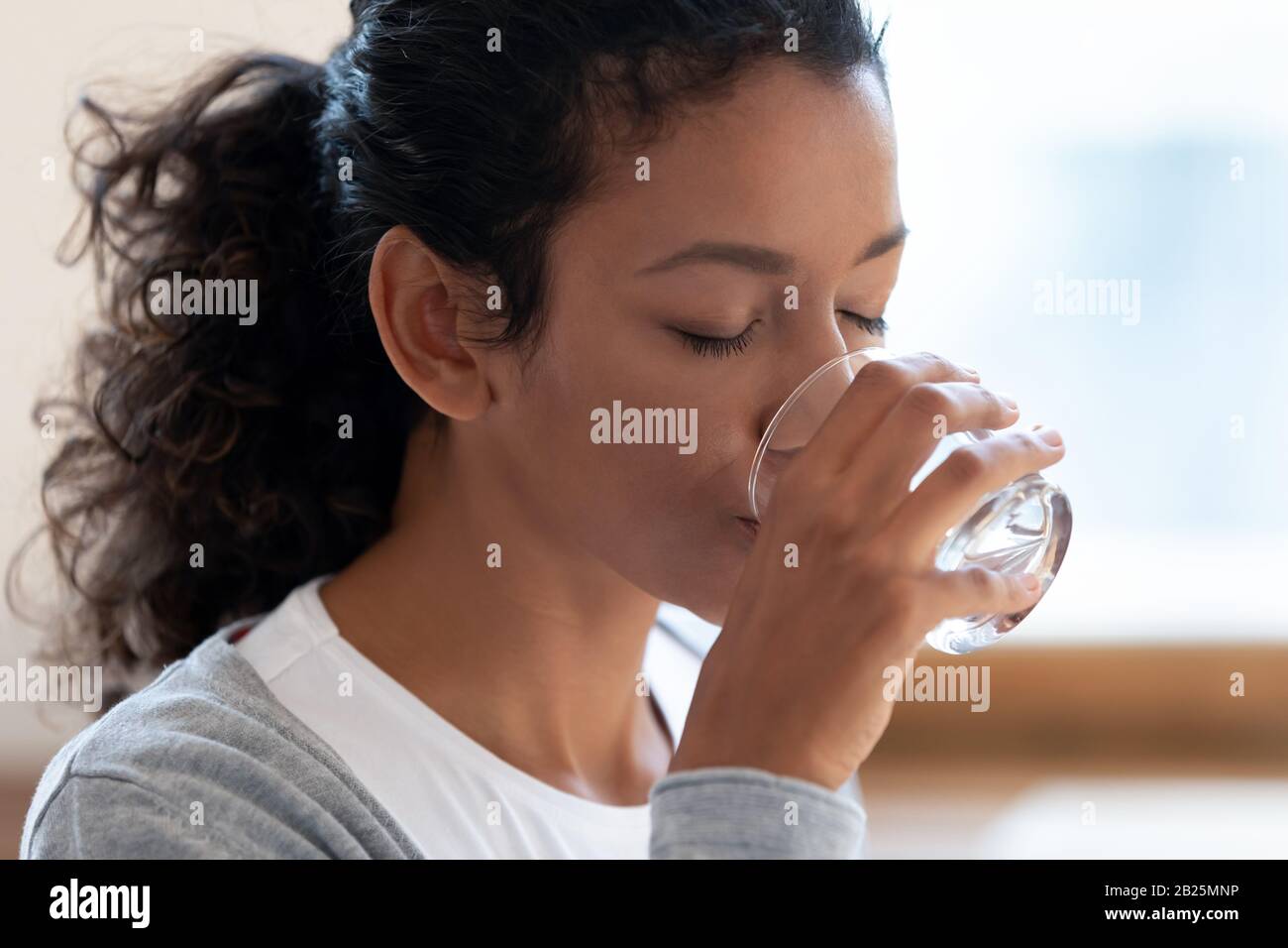 Sete afroamericana donna bere acqua minerale Foto Stock